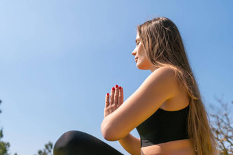 年轻的女人长头发健身教练运动服装紧身裤上衣伸展运动普拉提瑜伽席海阳光明媚的一天女健身瑜伽例程概念