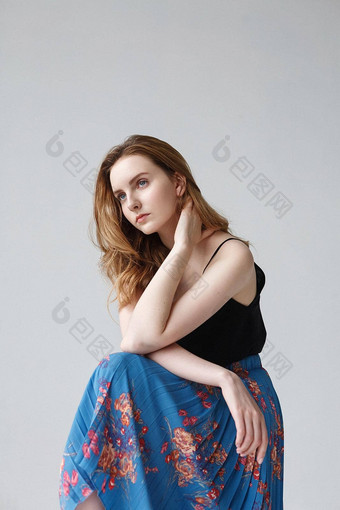 年轻的漂亮的女人蓝色的裙子在室内肖像可爱的深思熟虑的模型