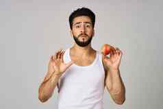 男人。白色t恤苹果手水果健康的食物光背景