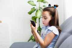 距离学习在线教育孩子们女孩研究首页前面智能手机孩子看在线漫画孩子们电脑上瘾父母的控制检疫首页