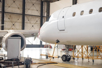 现代白色乘客<strong>飞机</strong>维护修复检查机场机库在室内
