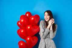 情人节一天美丽的浪漫的女孩做梦日期站可爱的心气球微笑蓝色的背景