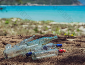 关闭垃圾填埋场脏透明的被丢弃的空玻璃酒精饮料瓶垃圾地面森林自然海公园酗酒上瘾问题坏习惯生态问题环境污染