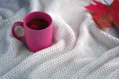 粉红色的茶杯白色围巾背景陶瓷杯秋天叶白色毯子热喝