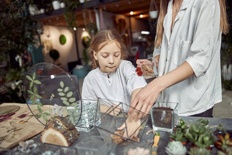 高加索人自信快乐花店工作年轻的女儿使作文玻璃石头植物植物商店