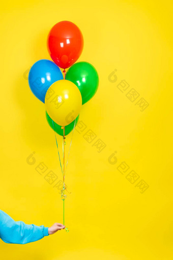 女手持有群色彩斑斓的气球聚会，派对现在概念绿色红色的黄色的蓝色的气球手孤立的黄色的使用