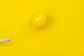 女手持有飞行黄色的<strong>气球</strong>聚会，<strong>派对</strong>现在概念黄色的<strong>气球</strong>手孤立的黄色的使用单色横幅复制空间