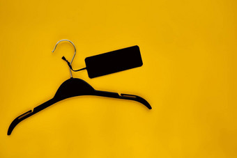 黑色的外套悬挂器黑色的纸标签孤立的黄色的纸背景服装标签标签空白模型模板的地方设计黑色的星期五最后出售横幅