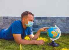 男人。穿脸面具持有地球全球世界地图手检疫保护传播病毒旅行疫情流感大流行冠状病毒法律顾问“非典”科维德病毒概念