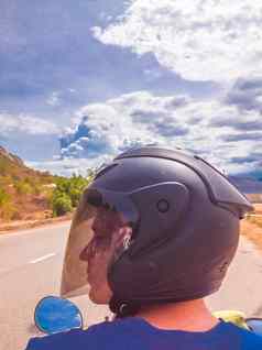 失去肖像快乐骑摩托车的人男人。头盔摩托车夏天路旅行摩托车冒险巡回演出摩托车背景高前山旅游旅行概念复制空间
