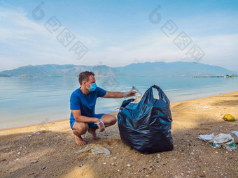 男人。手套选择塑料袋污染海问题泄漏垃圾垃圾垃圾海滩沙子引起的人为造成的污染运动清洁<strong>志愿者</strong>概念