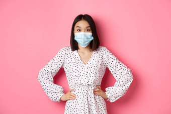科维德检疫生活方式概念可爱的朝鲜文女人衣服脸面具预防措施冠状病毒站粉红色的背景