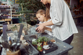 高加索人自信快乐花店工作年轻的女儿使作文玻璃石头植物植物商店
