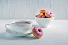 杯子热可可甜甜圈白色背景美味的粉红色的甜甜圈热可可杯甜蜜的早餐