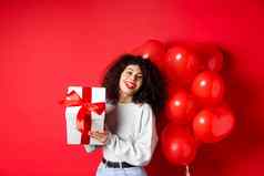 假期庆祝活动快乐生日女孩持有礼物摆姿势聚会，派对氦气球微笑兴奋相机红色的背景