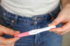 年轻的女人持有负怀孕测试首页怀孕测试显示负结果关闭