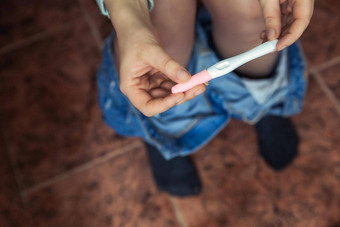 年轻的女人检查结果怀孕测试浴室特写镜头生活家庭妈妈。婴儿概念
