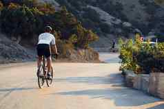 男人。骑自行车的人骑车路自行车在户外太阳集