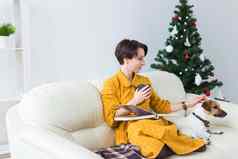 女人读取书前面圣诞节树狗杰克罗素梗圣诞节假期宠物