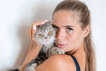 有吸引力的年轻的女人长头发拥抱宠物微笑室内肖像可爱的女人玩猫品种英国褶皱健康的生活方式和谐宠物