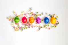 行色彩斑斓的画复活节鸡蛋孤立的白色背景包围花前视图背景快乐复活节概念现代设计