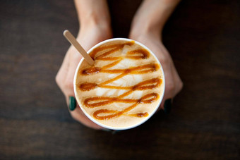 焦糖大咖啡纸杯牛奶女士手木表格卡布奇诺咖啡拿铁喝杯咖啡表格平躺视图杯咖啡馆牛奶牛奶绘画热咖啡女孩
