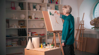 年轻的女人艺术家短头发绘画上分支机构树绿色颜色艺术工作室