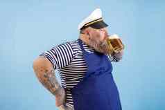 快乐matuer大小男人。水手西装饮料新鲜的啤酒光蓝色的背景