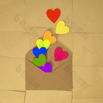 棕色（的）工艺纸信封彩虹色彩斑斓的心平原棕色（的）背景纹理前视图情人节一天浪漫的概念复制空间