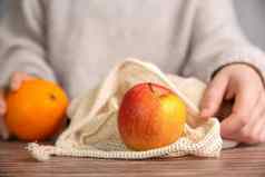 女手环境友好的网袋购物食品杂货新鲜的水果苹果橙子生态友好的网木表格