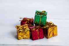 桩彩色的闪亮的礼物盒子复制空间白色木背景现代复古的圣诞节设计色彩斑斓的礼物假期概念