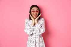 旅游生活方式概念兴奋亚洲女人可爱的太阳镜衣服尖叫幸福相机站惊讶粉红色的背景