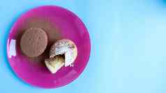 凝乳蛋糕撒巧克力糖衣糖粉红色的板蓝色的背景甜点小蛋糕白色烤饼干艾里纹理复制空间视图