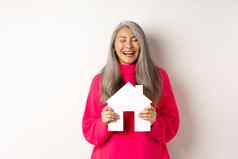 真正的房地产快乐亚洲祖母笑眼睛关闭持有纸房子模型做梦纸房子模型站白色背景