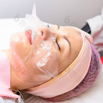 透明的mask-film脸女人访问美容师面部护理