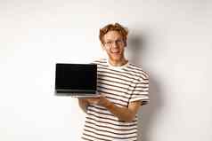 有趣的红色头发的人男人。眼镜显示移动PC屏幕广告微笑的家伙红色的头发演示了促销横幅显示白色背景