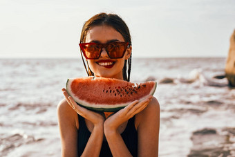 快乐的女人太阳镜吃西瓜海洋