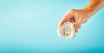 男人。持有牙蓝色的背景访问牙医口腔学广告概念牙科健康
