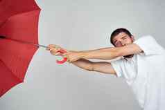 男人。白色衬衫红色的伞保护雨光背景
