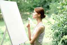 快乐的女人艺术家自然画架有创意的艺术