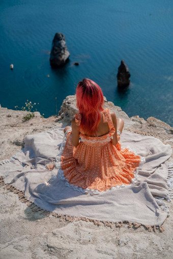 女孩红色的头发坐在回来查看器野餐毯子橙色衣服<strong>峰会</strong>山<strong>背景</strong>海岩石海