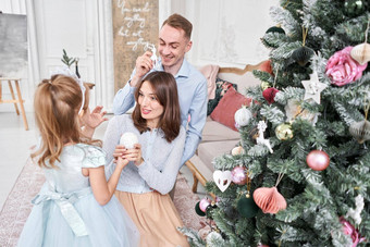 爱的家庭妈妈爸爸女儿父母婴儿孩子有趣的圣诞节树白色壁炉在室内快乐圣诞节快乐一年快乐的漂亮的人