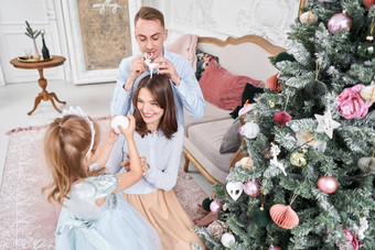 爱的家庭妈妈爸爸女儿父母婴儿孩子有趣的圣诞节树白色壁炉在室内快乐圣诞节快乐一年快乐的漂亮的人