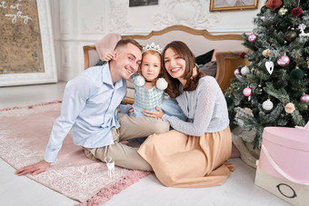 爱的家庭妈妈爸爸拥抱女儿父<strong>母婴儿</strong>孩子有趣的圣诞节树白色壁炉在室内快乐圣诞节快乐一年快乐的漂亮的人