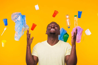 塑料回收问题生态环境灾难概念惊讶非洲美国男人。黄色的背景垃圾担心生态灾难