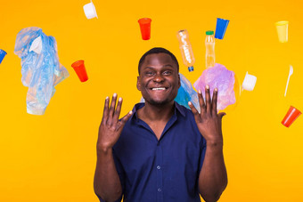 问题垃圾塑料回收污染环境概念非洲美国男人。站垃圾黄色的背景