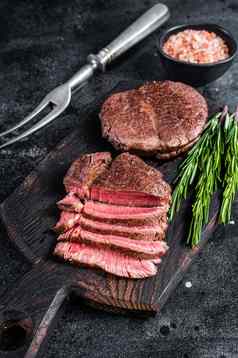 角牛排里脊肉烤切片肉牛肉牛排黑色的背景前视图