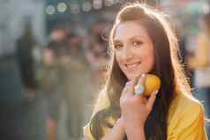 女孩黄色的衬衫柠檬手城市街肖像女人黄色的
