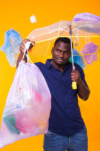 问题垃圾塑料回收污染环境概念困惑男人。携带垃圾袋黄色的背景