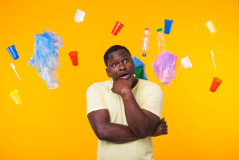 问题垃圾塑料回收污染环境概念惊讶非洲美国男人。垃圾黄色的背景思考生态